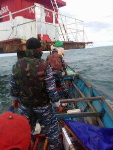 Personel Kal Bokori dibantu beberapa nelayan yang kebetulan lewat, mengganti bendera merah putih yang telah rusak di Mercu Suar Karang Umarang, Perairan Ambalat.