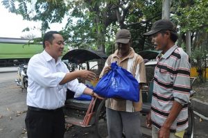 Yon Irawan (kiri) memberikan langsung paket sembako gratis ke tukang becak di wilayah Tanjung Perak