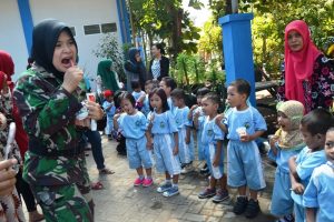 Letda Laut (K/W) Drg. Dyah Selvia Putri sedang mengajarkan cara menggosok gigi yang benar kepada para siswa Kelompok Bermain Rumah Pintar Dolphin.